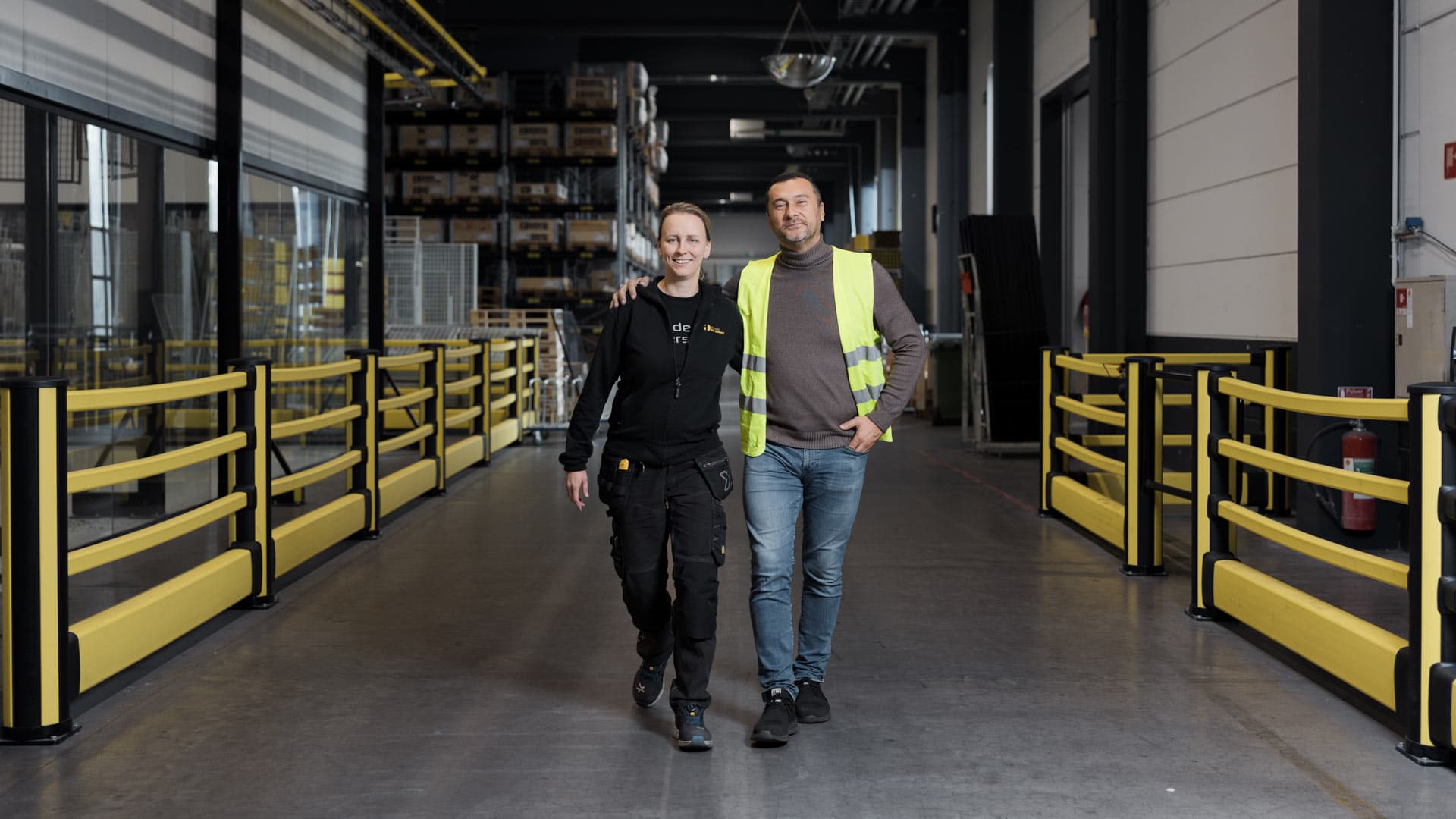 Two employees walking through an industrial warehouse 