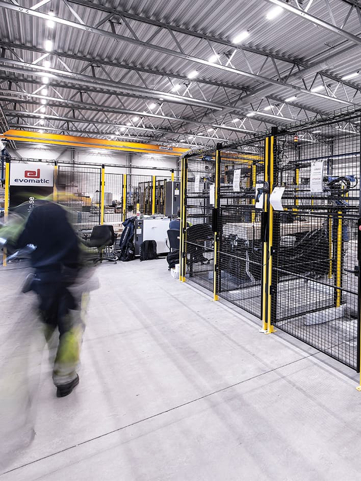 Stationaire geautomatiseerde opslag- en verpakkingsmachines, waaronder transportbanden, sorteermachines en palletiseermachines in een magazijnomgeving