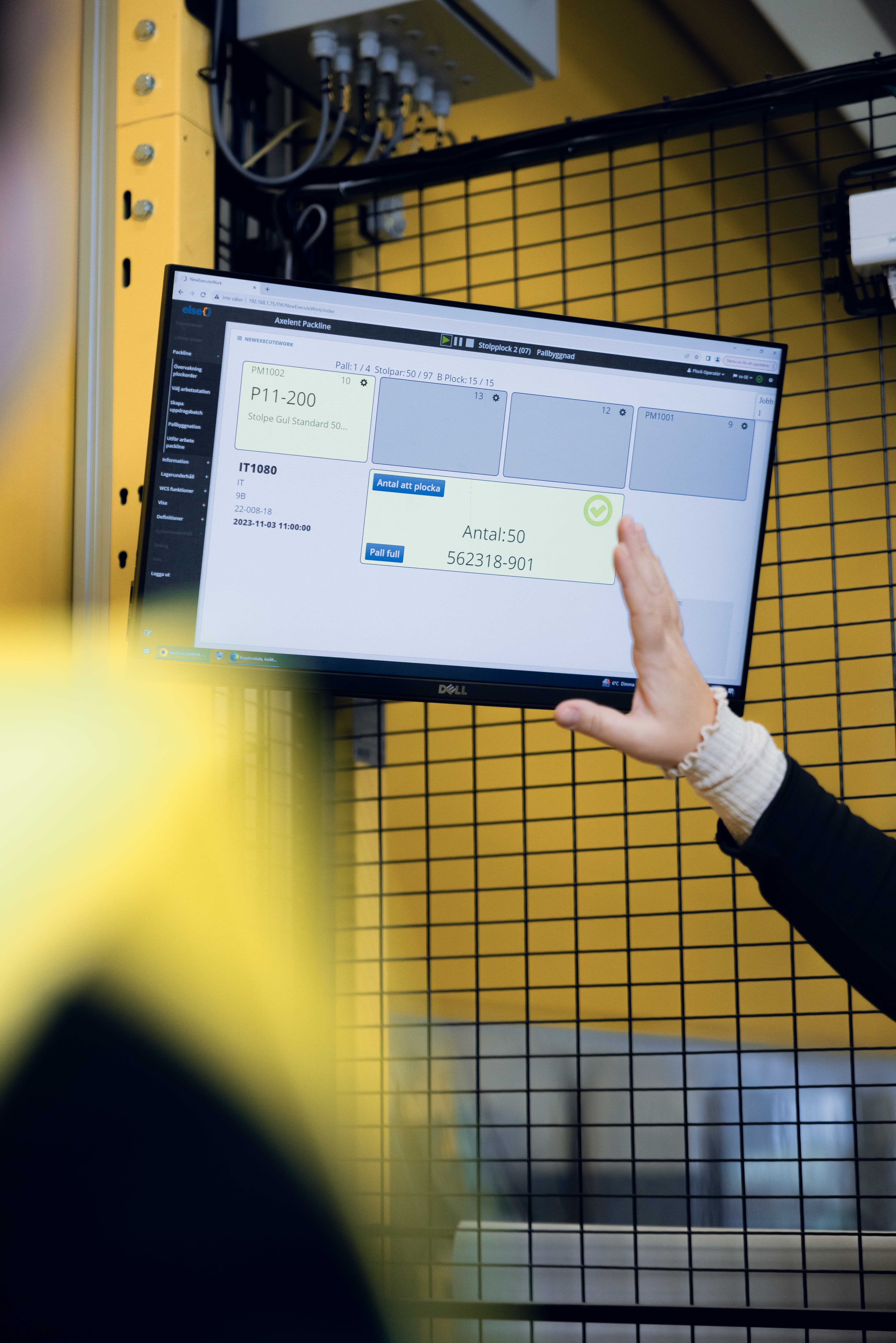 Employee monitoring production data on a digital screen at Axelent