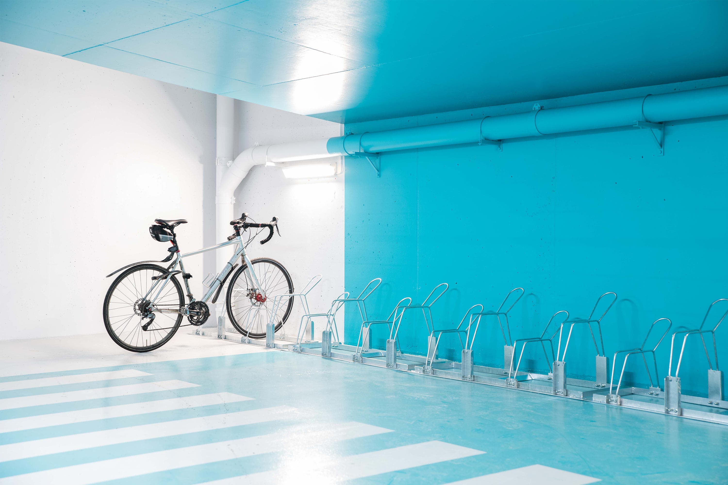 Markmonterade cykelställ i ett lagringsutrymme med en cykel i stället