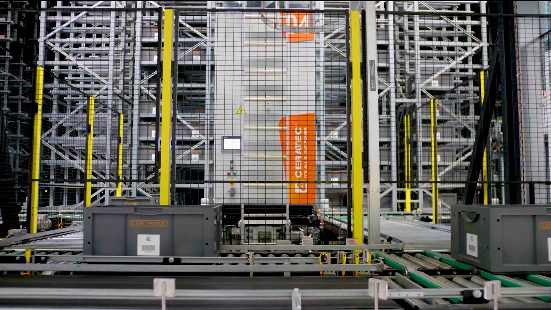 Automated warehouse storage system with safety fences in front of shelves and containers