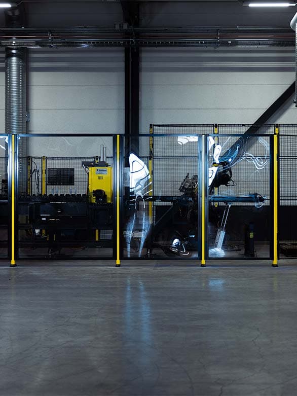 A robotic workstation enclosed by transparent safety fencing, ensuring secure machine operation while maintaining visibility. The image highlights the role of monitoring systems as an alternative to movable guards, enhancing industrial safety and efficiency.