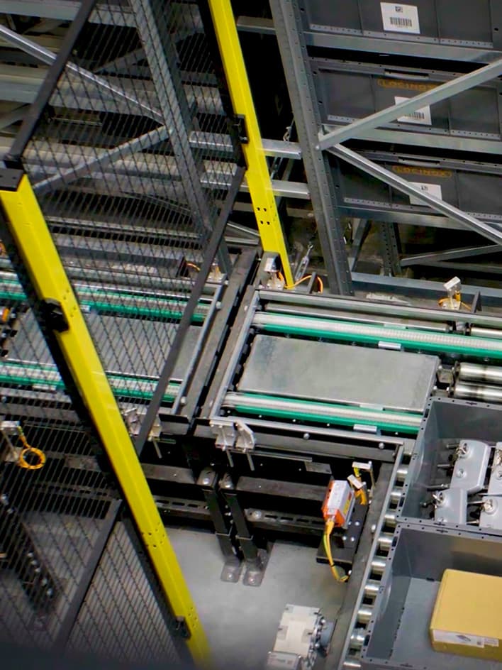 Conveyor system with safety fencing, marking a restricted or hazardous area in a warehouse