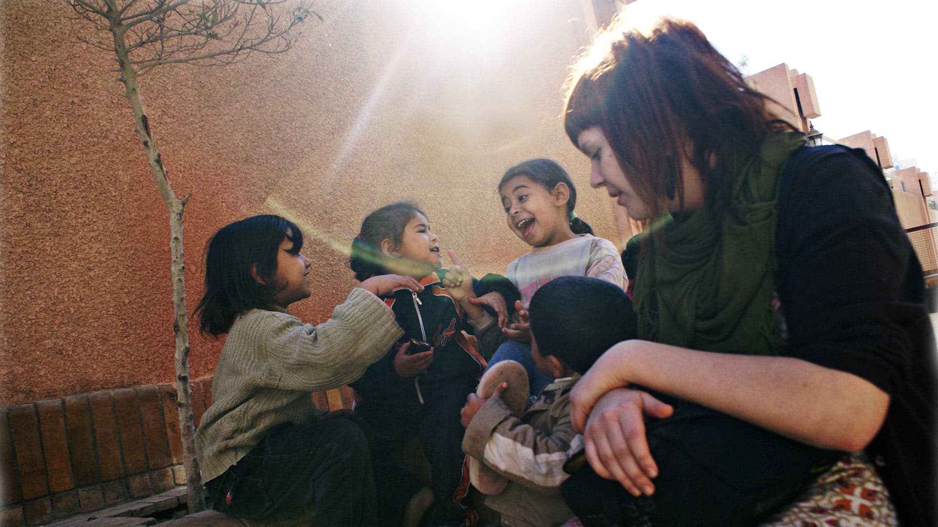 Woman sitting outdoors with children