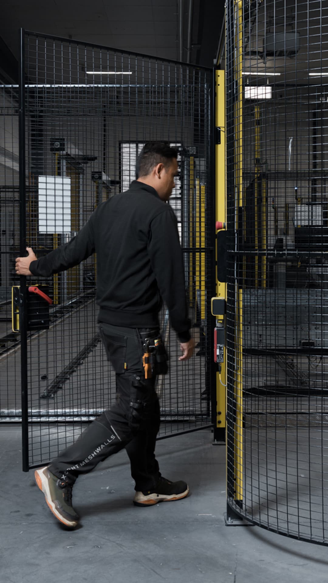 Worker entering machine cage by a safety door