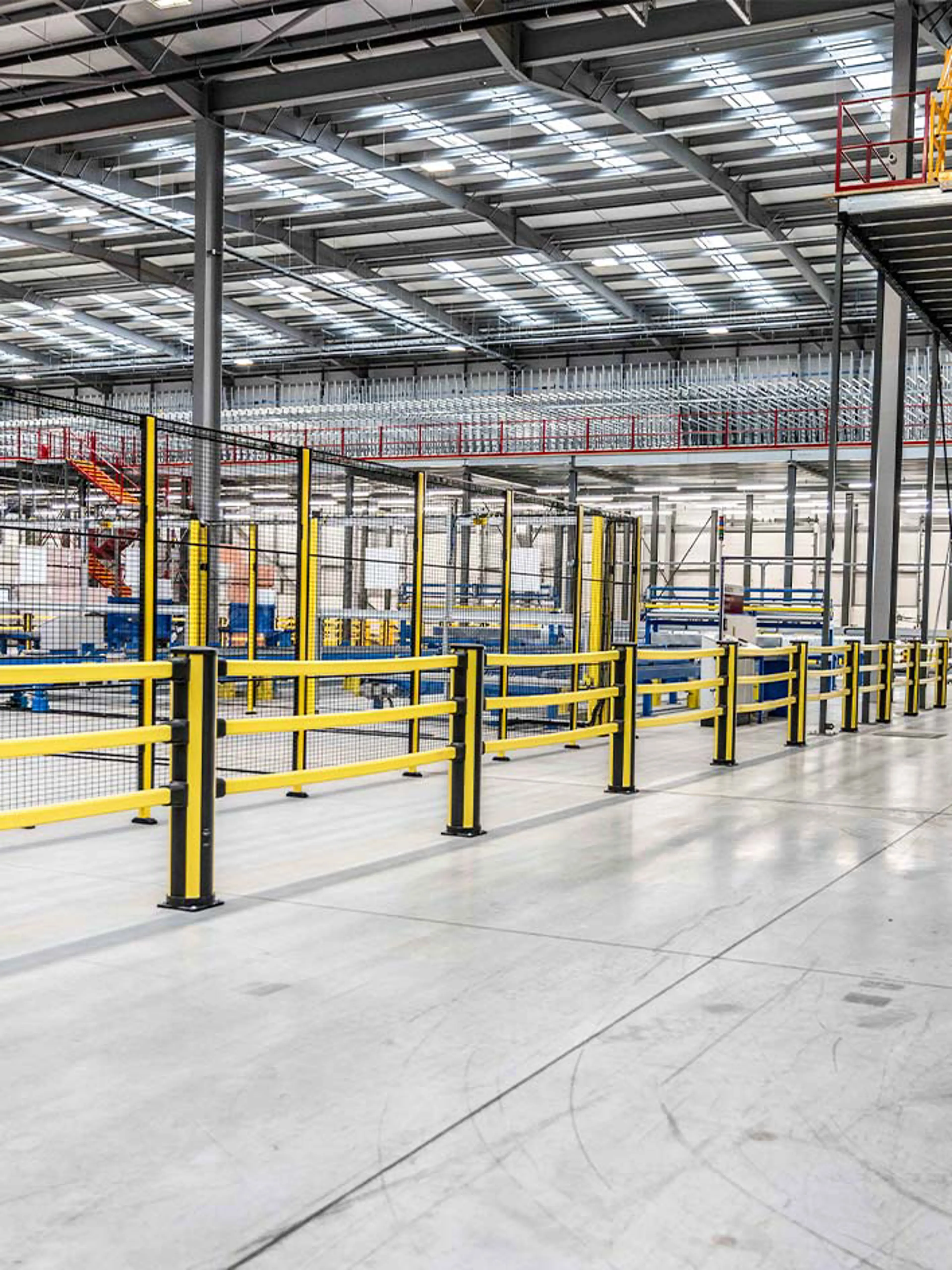 Industrial safety barriers and guardrails in a modern warehouse, designed for fall and impact protection. These crash barriers help protect employees and equipment, ensuring workplace safety in high-traffic environments.