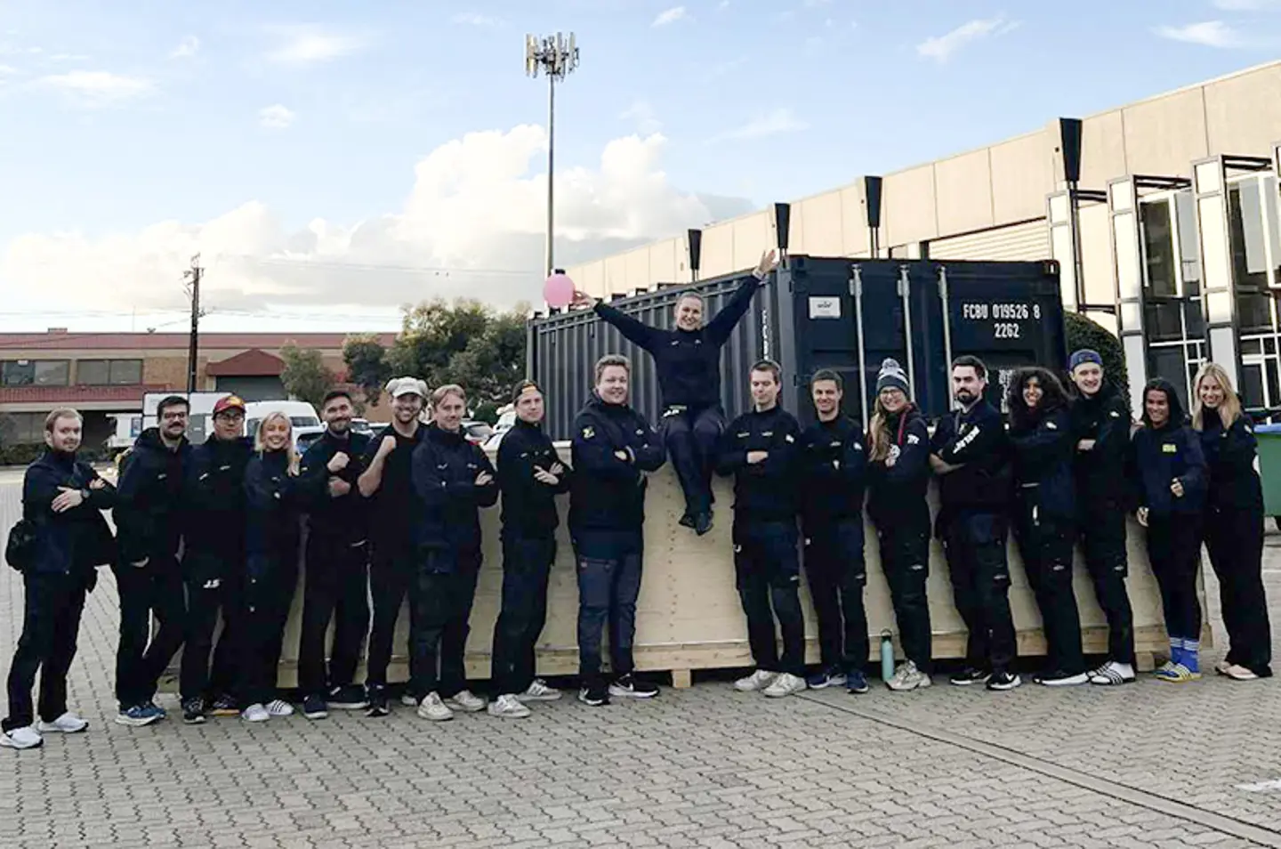 All mambers of the JU Solar Team posing infront of a black container